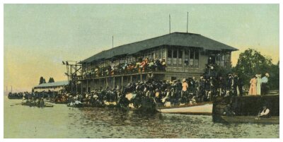 (Image: Crowds Fill the Verandah and Shoreline Overlooking
  the Water)