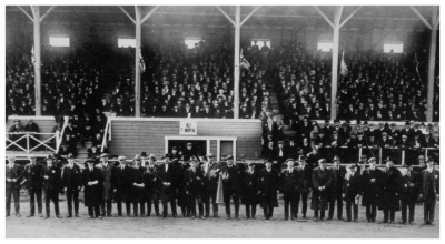 (Image: Officials Pose in Front of the Crowded Stands)